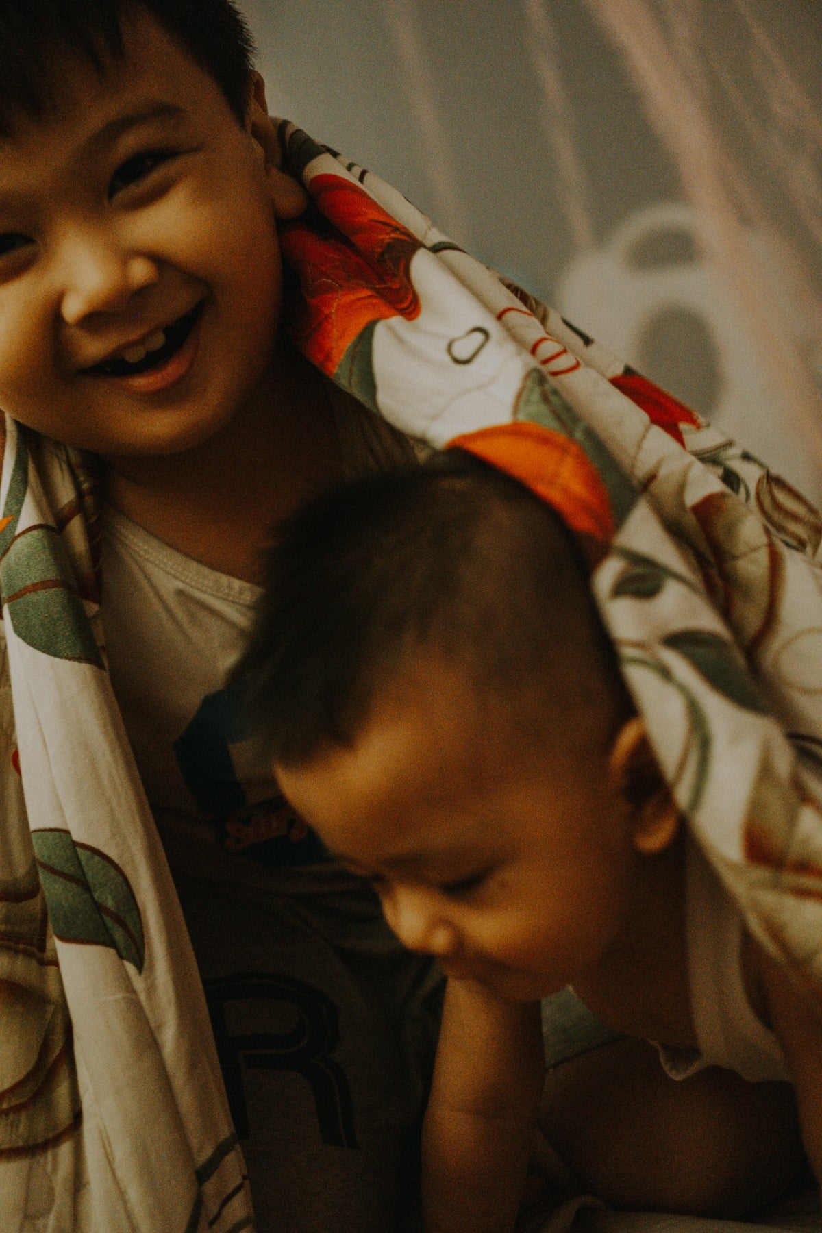 a young boy holding a baby wrapped in a blanket