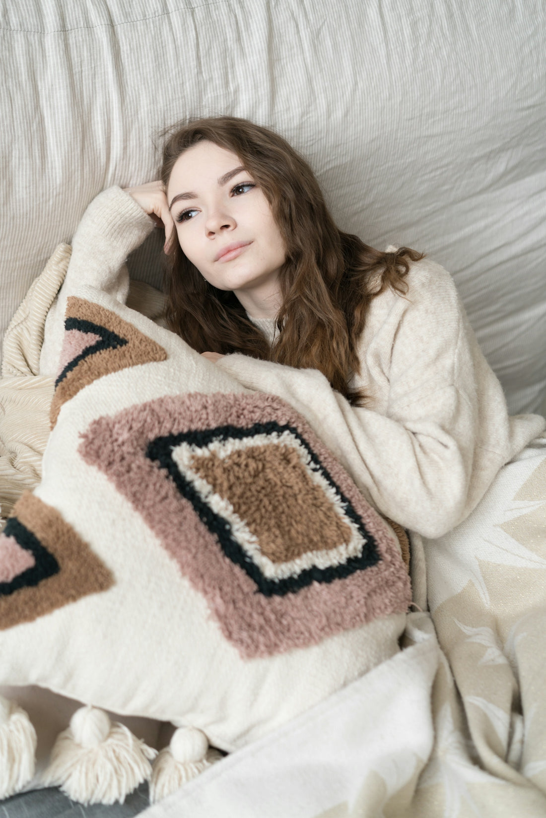 a woman laying on top of a bed under a blanket