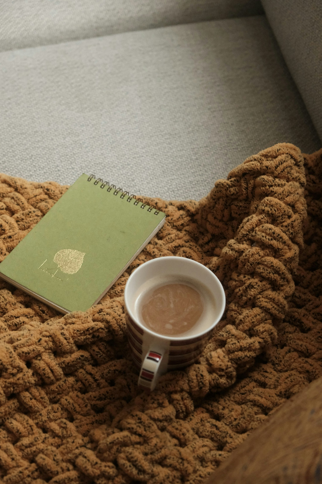 a cup of coffee sitting on top of a blanket