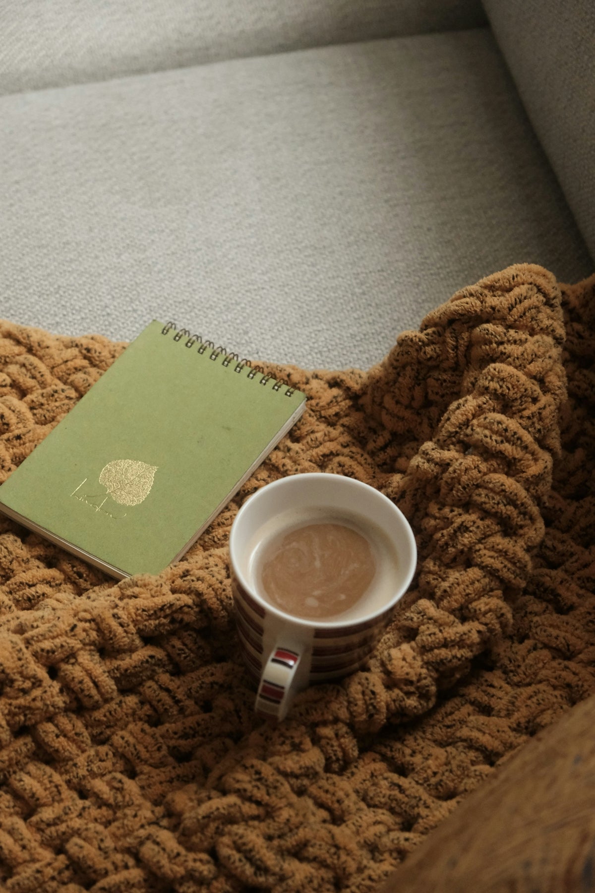 a cup of coffee sitting on top of a blanket