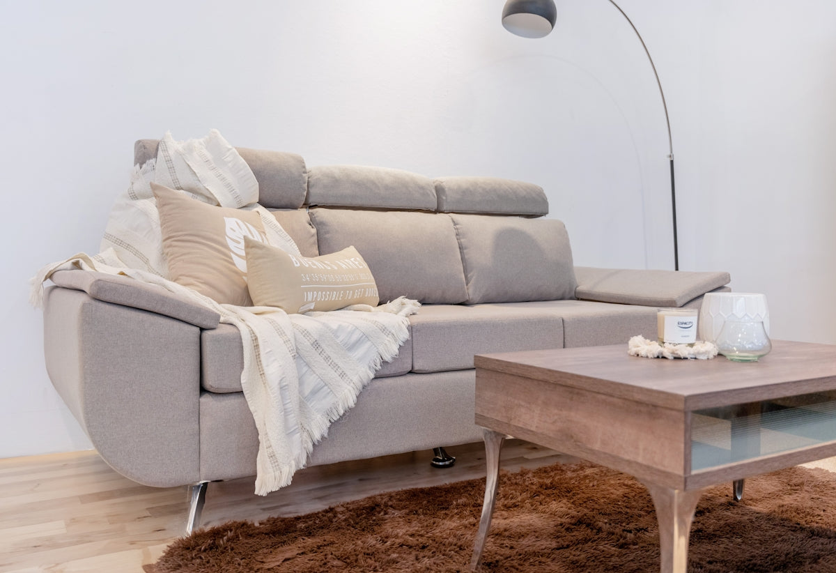 A comfortable sofa with throw pillows and blanket.
