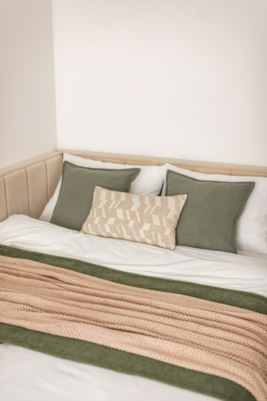 A neatly made bed with pillows and a blanket.