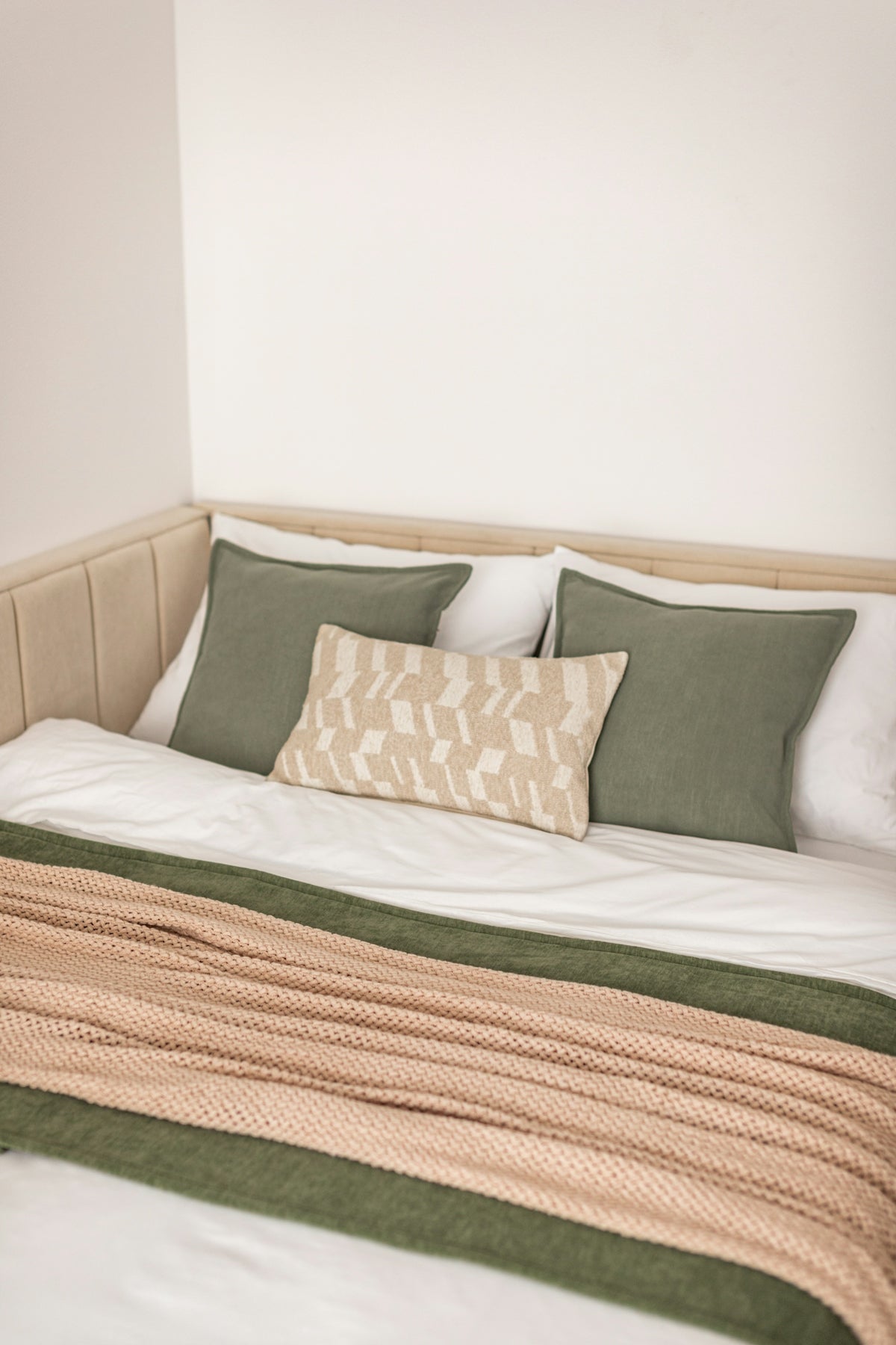 A neatly made bed with pillows and a blanket.